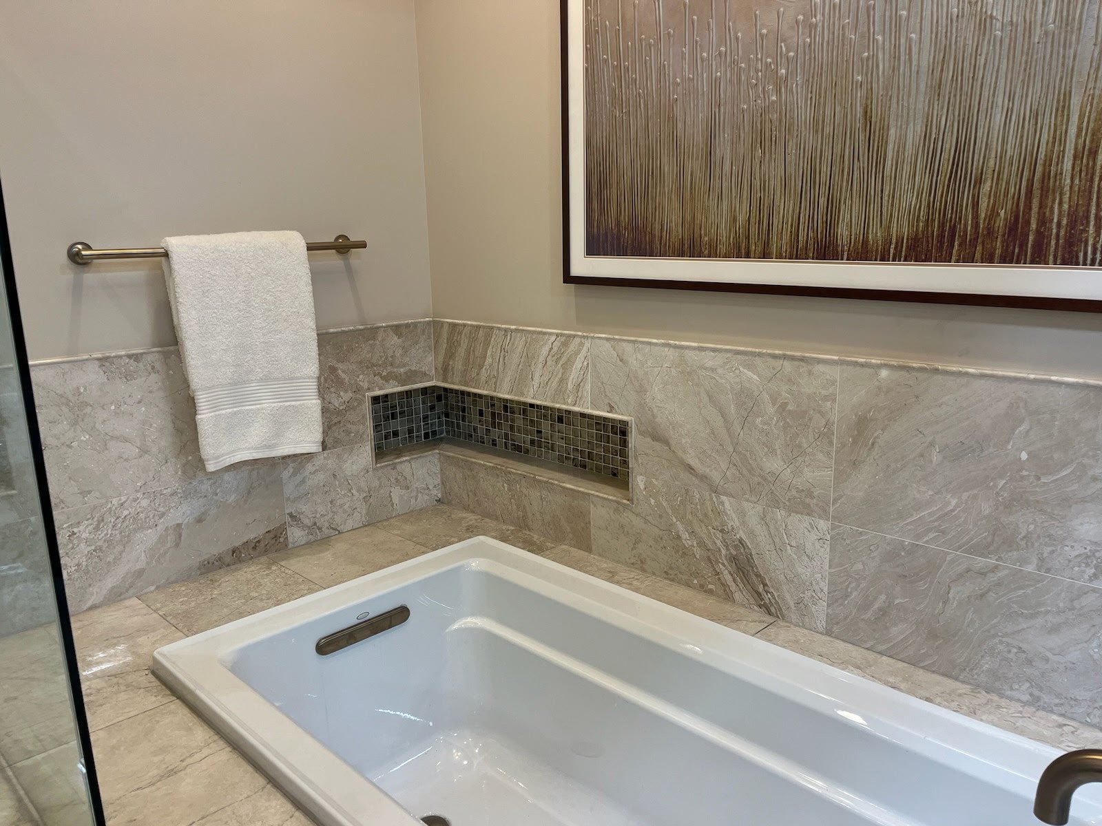 Built-in soaking tub with marble tile surround and inset niche