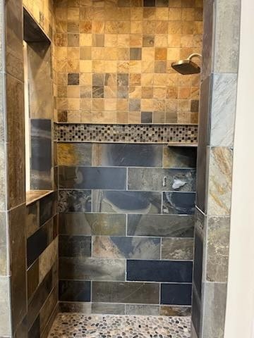 Shower with slate-look horizontal tile and pebble floor